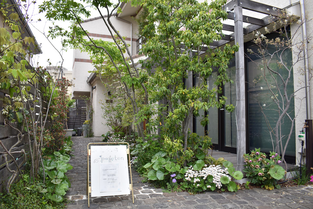 荒谷さんが手がけた愛知県名古屋市千種区にあるカフェ「papiton（パピトン）」の庭では、奥まで散水チューブを這わせている。右側のウッドデッキはテラス席に。