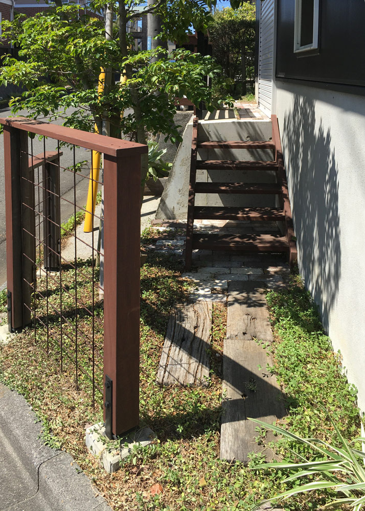 道路から家へと続く階段は、フェンスと同色に。