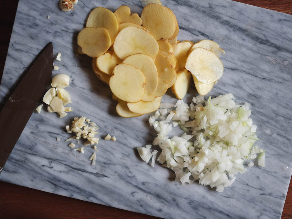 玉ねぎ、にんにく、ジャガイモを切る