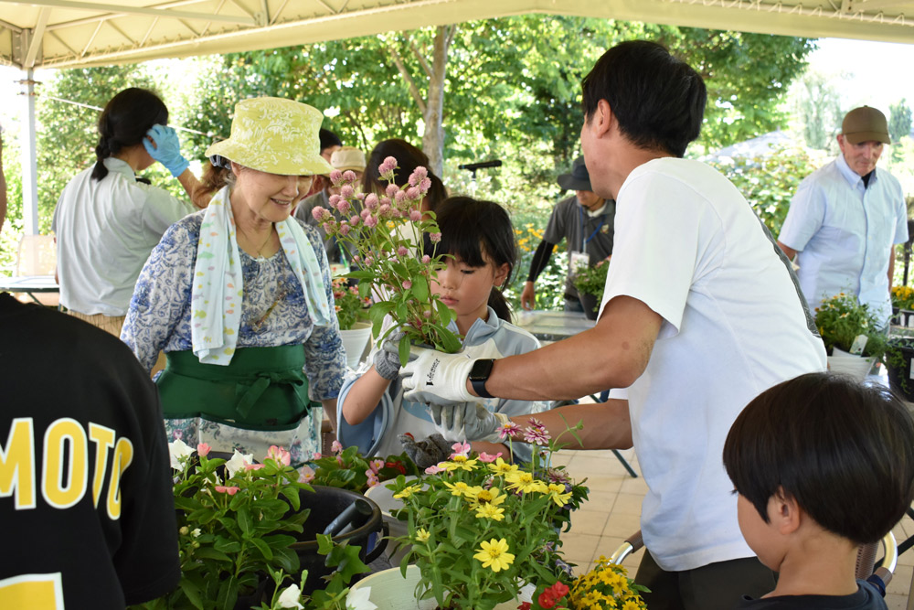 親子向けの寄せ植え教室「わくわく体験塾」で子どもたちの寄せ植えを見守るケイさん。