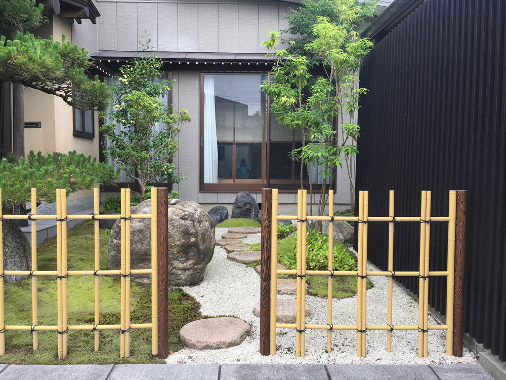 四ツ目垣の透けた向こうに飛び石や景石が見える