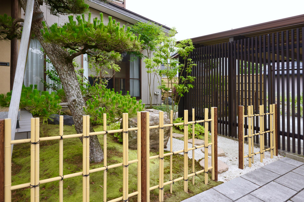 駐車場のこげ茶色の立て格子で手前の四ツ目垣根が引き立つ