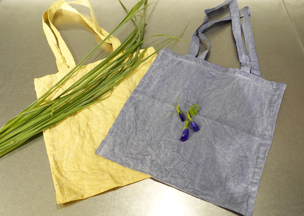 ハーブで染めたエコバッグ。レモングラス（フレッシュ）は黄色に、バタフライピー（ドライ）は青に染まります。