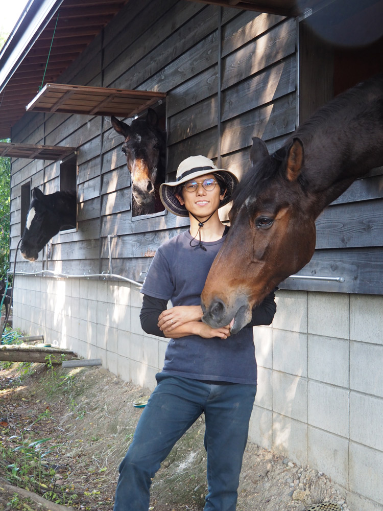 鵜飼農園現社長・鵜飼幸治さんの息子の鵜飼勇希さん。お気に入りの愛馬と。現在、鵜飼農園では、高木類を勇希さん、下草類の生産を妻・敦美さん、ポット苗の生産や量販店用のコンテナ栽培を弟・孝徳さん夫婦がそれぞれ行っている。